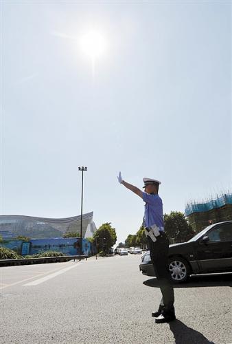 烈日当头，毫无遮挡，成都交警六分局民警李光耀仍笔直地站在路口指挥交通 